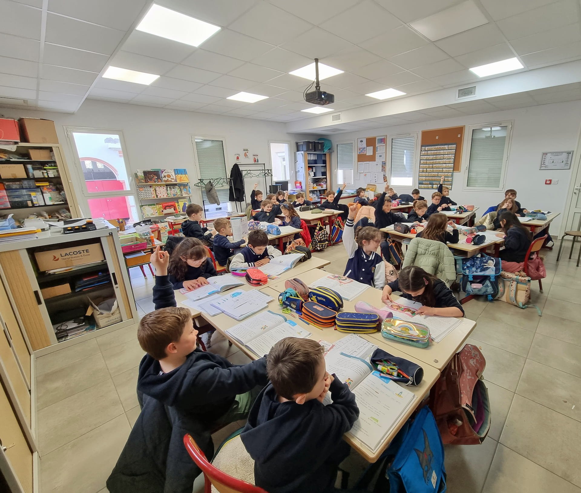 Collégiens assis dans des fauteuils, en train de lire un livre